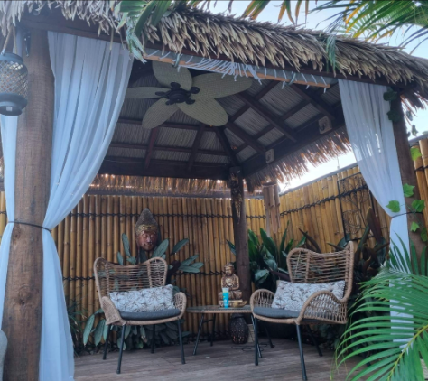 Relaxing outdoor Bali hut space with synthetic thatch roofing.